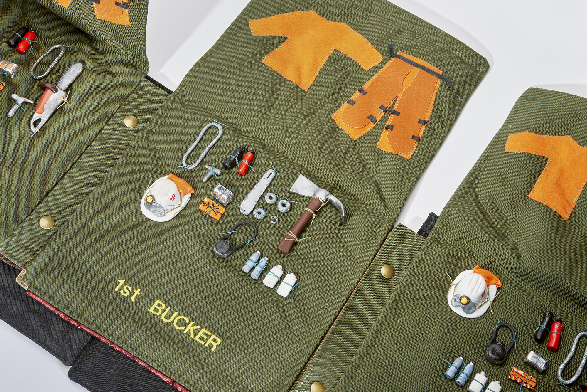 Kim Abeles and the Firefighting Women of Camp 13 / Valise 2 - Tools from the series, Valises for Camp Ground: Arts, Corrections, and Fire Management in the Santa Monica Mountains
2018
Hand constructed “backpack” valise made with Cordura, Velvet, Clay miniatures of firefighting tools, Embroidered names of each position on a fire crew, brass hardware 
Size: Closed: 23” x 10” x 14”   Open: 10” x 167” x 22"
This inaugural Camp Ground project with inmates from Camp 13 was managed by the Armory Center for the Arts, with Kim Abeles as the first commissioned artist. Camp Ground: Arts, Corrections, and Fire Management in the Santa Monica Mountains is made possible by the National Endowment for the Arts and the Los Angeles County Arts Commission.